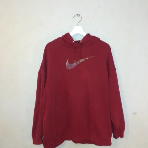 Nike vinröd hoodie strl L - Vinröd hoodie Nike strl L. Fint skick förutom en liten fläck (se bild). Har ej testat om den går bort med exempelvis vanish. Eller om man vill vara kreativ och så över något märke 😍