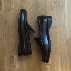 Johnston & Murphy penny loafers -  burgundy röda loafers från johnston & Murphy, jättefint skick och äkta läder knappt använda, ej randsydda