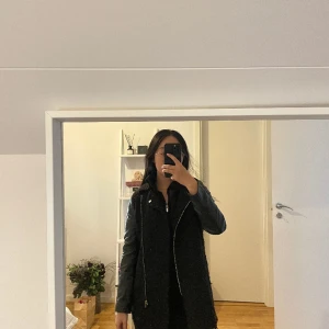 Skinn kappa från H&M - Svart kappa från H&M med skinndetaljer och ull imitation. 