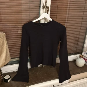 Svart topp med utsvängda armar - Jättefin svart tröja med utsvänga armar. På etiketten står de st L men skulle säga att det är en M.