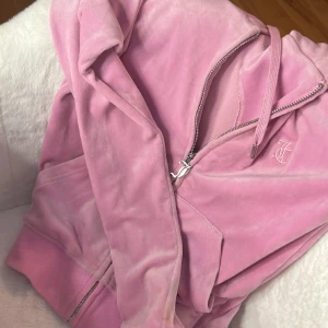 Juicy couture tröja zip up nelly  - Säljer en jätte fin rosa juicy couture tröja som är köpt från Nelly i storlek XXS, super bra skick och knappt använd, tvättar innan skickar efter köp ,säljer pga inte kommer till användning längre. står inte för frakt hör av dig för mer bilder!