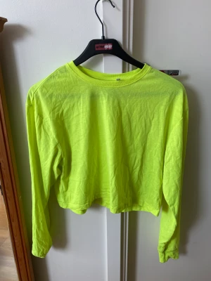 Neongul topp från Weekday - Neongul lite croppad topp från Weekday. Endast använd vid fåtal tillfällen. Strl XS men passar även någon med strl S.