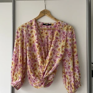 Somrig omlottopp - Somrig blommig gul/rosa blus i omlottmodell. Oanvänd. 