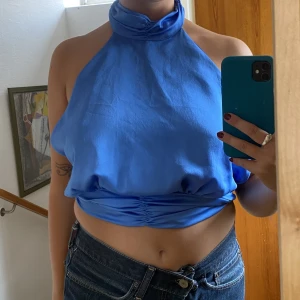 Blå silkestopp  - Säljer denna blåa  silkestoppen med öppenrygg för 60kr + frakt!  Storlek M men passar även som S. Använts endast ett fåtal gånger och har inga skador eller slitningar. 