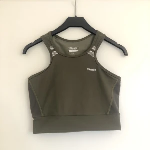 Träningstopp  - Säljer denna träningstopp då jag har för många. I fint skick. Trycken sitter som om toppen vore ny förutom på insidan i nacken. Jag brukar ha problem med att träningstoppar skaver vid skulderbladen men den här är jättemjuk och skön. 