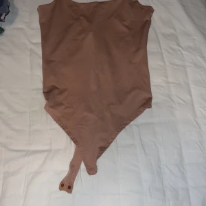 Body - Body i stretchigt material. Beige/antikrosa färg. Sparsamt använd