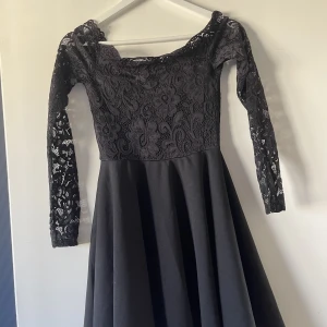 Svart spetsklänning med offshoulder - En svart klänning men fin spets och offshoulder. Helt oanvänd!!!! Strolek s från nelly