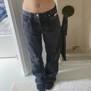 Jeans  - Baggy jeans med coolt styck på backfickorna och även ena fram fickan. In sydda i midjan och lite slitna på hälen, annars fint skick. Storleken är lite mindre i midjan. 