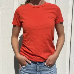En orange tshirt med ett litet tryck på bröstet