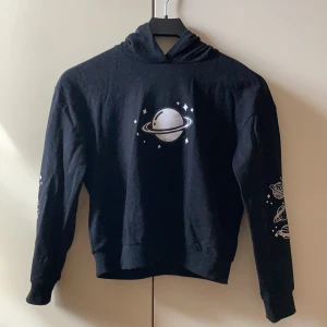 Svart hoodie med tryck  - Säljer denna svarta hoodie med planet-tryck då den inte passar mig längre. Använd få gånger och är i bra skick! 