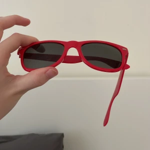 Röda solglasögon - -