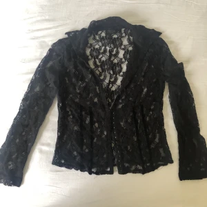 Korsettliknande spetskjorta strl L - Svart spetsskjorta i storlek L från märket Fransa. Korsettspänneslutning på framsidan. I gott skick utan tecken på användning. Finns ingen bild med plagget på. Köparen står för frakt. Dma gärna vid frågor eller funderingar 