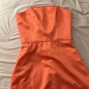 Lång balklänning storlek s - Oanvänd korallfärgad  balklänning lång hela vägen ner med pärldetaljer i midjan  