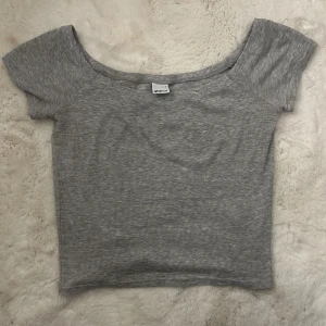 Grå topp - Säljer denna söta off shoulder topp. Den går att använda både som offshoulder men även som en vanlig tröja om man vill det. Väldigt bra skick. Tröjan är från Gina tricot❤️🫶🏼