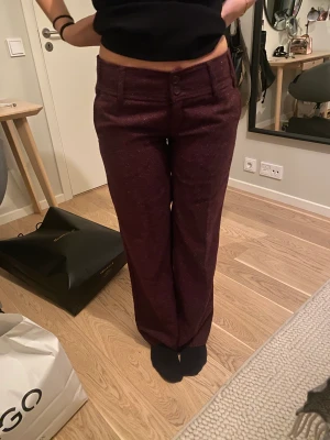 Vinröda byxor  - Vinröda byxor som är lågmidjade och långa. 