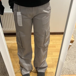Gråa cargo pants  - Säljer ett par gråa cargo pants mid/low waist då de är lite för stora för mig. Prislapp finns kvar och de är helt oanvända. Nypris 500. 315 inkl ospårbar frakt. 355 kr inkl spårbar frakt.