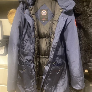 Jacka - Säljer min canada jacka pågrund av att jag vill inte använda den länge den är i perfekt skick, använd den i 3 månader. Pälsen kommer inte med jackan eftersom vill ha den på min andra canada jacka därför är det en bra pris på jackan,kan skicka mer bilder 