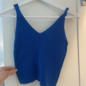 Blå topp - Blå stickad topp i jättefin färg! Köpt på en marknad i Spanien men har inte används någon gång!