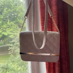 En beige handväska med gulddetaljer💛 Perfekt för balen eller likande ☺️ Som ny!