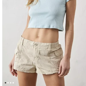 Lågmidjade Cargo Shorts - Beiga lågmidjade cargo shorts i storlek S, original pris är 399 kr från urban outfitters. I perfekt skick, använt fåtal gånger. Gratis frakt.