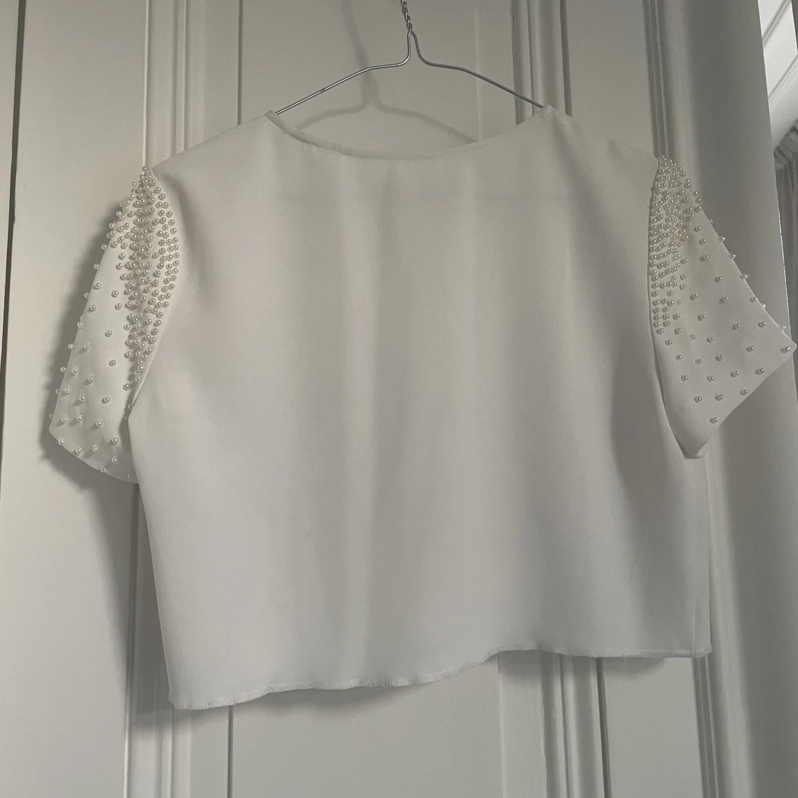 Vit kort top med fina pärlor på ärmarna  - 91