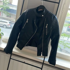 Bikerjacka - Skinnjacka. Sitter tajt trots strl 38. Snygga detaljer. Aldrig använd. 
