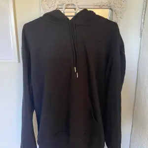 En svart basic hoodie i storlek M. Fint skick.