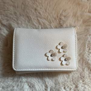 Säljer denna vita plånbok från don Donna med blommor på🤩 Super snygg, men har en liten gul fläck men den syns knappt😋