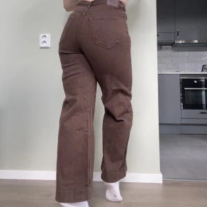 STRADIVARIUS Bruna Jeans (40) - Bruna jeans byxor från Stradivarius. Jeans med hög midja och smal passform vid midjan, släpper till en lös passform över benen. Är liten för mig som brukar ha storlek 40 i jeans🍄