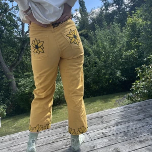 Byxor med solrosmönster  - Ett par gula byxor med solros mönster som är påmålat. Från början från monki. Passar mig bra som har storlek 36-38 på byxor. 