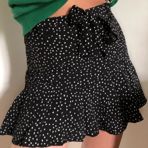 Prickig volang kjol Zara  - Svart kjol med vita prickar. Perfekt till sommaren! Kjolen har inbyggda shorts, se bild 3. Obs första bilden är lånad men de andra är mina. Kan även skicka fler bilder i dm. Går inte att köpa längre!! NYPRIS: 250kr 