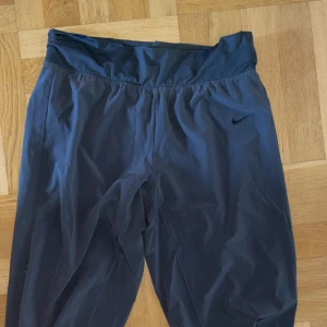 Nike träningsbyxor  - Nike träningsbyxor, lös modell 3/4, mörkgråa. 
