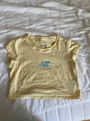 New Balance topp  - Cropped t-shirt i ljusgul från NB. Fint skick! 