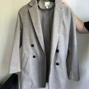 Kappa - Grå kappa från H&M. Säljer då den inte längre kommer till användning ❣️