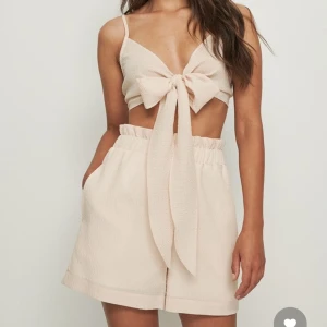 Strandset - Strand set från NAKD i storlek 36. Setet består av shorts och en top som knyts vid bysten. Mycket sött att ha över en bikini när man är på stranden. Bara använts en gång och är normal i storleken. Den är i färgen beige. 