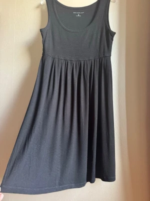 Svart skön solklänning - En enkel och bekväm svart klänning i viskos (rayon) med ärmlös design och rundad halsringning. Klänningen har en rynkad kjol och är tillverkad i ett mjukt, skönt material som passar perfekt till solklänning eller mysklänning