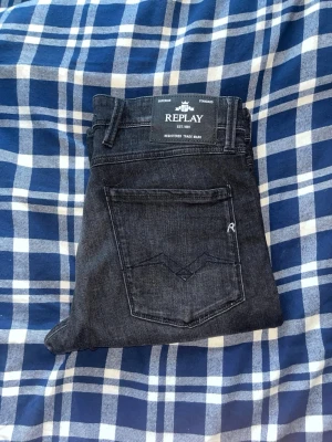 Replay Anbass jeans  - Snygga  slim fit jeans från Replay med klassisk femficksdesign och diskret logga på bakfickan. Jeansen har raka ben och är tillverkade i ett mjukt denimtyg som sitter skönt. Perfekta för en trendig och avslappnad stil.JAG SKICKAR EJ FLER BILDER NÄR JAG BÄR JEANSEN! för bättre inblick i passformen rekommenderar jag att googla på modellnamnet. För storleksguide kolla måtten noggrant då jeansen alltid kan vara uppsydda heller krympta och jag ej tar emot returer :) s6,2