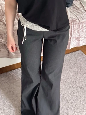 Vita spetsiga trosor med rosett - Säljer ett vitt spetsbälte med dekorativ rosett framtill. Bältet har ett romantiskt spetsmönster och knyts med tunna band för en söt och feminin look. Perfekt att styla över jeans eller byxor för att ge outfiten en extra detalj.🌷🌟🌟