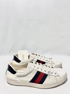 Gucci Ace Vita Sneakers - Gucci Ace skor i en riktigt clean model! Super fint skick, inga defekter. 44,5 passar 45. Kontakta mig för fler frågor och funderingar!
