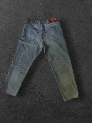 Diesel Jeans D-Lucas-J - Säljer ett par ljusblå Diesel jeans med rak pass form. Har dessutom lite snygga slitningar vid bak väcken.