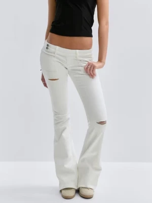 Vita bootcut jeans med slitningar - Snygga vita bootcut jeans med slitningar på låret och knät. Jeansen har låg midja, broderade bakfickor och utsvängda ben. Änvända 1 gång. 