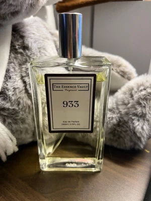 The Essence Vault 933 Inspired by Delina - The Essence Vault 933 Eau de Parfum (100 ml). En elegant och exklusiv doft inspirerad av Delina. Det är en modern, blommig doft med inslag av turkisk ros, litchi, rabarber och varma trätoner.  Parfymen är sparsamt använd endast ett fåtal gånger (se bilder) och har förvarats mörkt och svalt. Säljes utan tillhörande kartong.