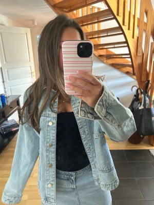 Ljusblå jeansjacka från ZARA - Snygg ljusblå jeansjacka från ZARA med klassisk krage, stora framfickor och knäppning framtill. Jackan har en avslappnad passform och är tillverkad i slitstarkt denimtyg. Perfekt för dig som vill ha en tidlös och trendig look.
