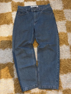Polar 93 denim jeans - Klassiska blå pilar skate co. jeans med rak passform och hög midja. Jeansen har fem fickor, bälteshällor och stängs med knapp och dragkedja. Tillverkade i kraftigt denimtyg som ger en tidlös look. Perfekta för dig som gillar vintage vibe och enkel stil.