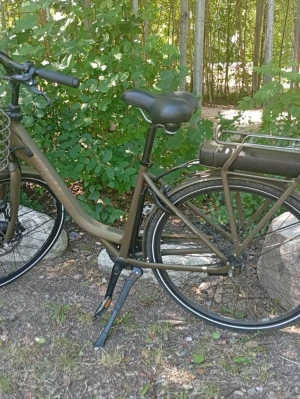 Olivgrön elcykel med pakethållare - Säljer en elcykel i olivgrönt med klassisk ram, svart sadel och handtag. Cykeln har pakethållare bak och batteri monterat under. Passar perfekt för smidiga vardagsresor och utflykter.