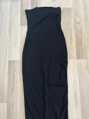 Axelbandslös klänning  - Jättefin axelbandslös klänning från Shein med slits nedtill. Har aldrig använts. Perfekt nu under sommaren eller till din nästa resa!  Postar mellan 1-3 dagar efter köp.  Hör gärna av dig om du har frågor eller vill ha fler bilder!