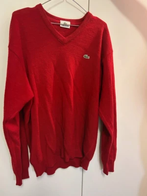 Röd stickad tröja från Lacoste - Röd stickad tröja från Lacoste. Den är i storlek M