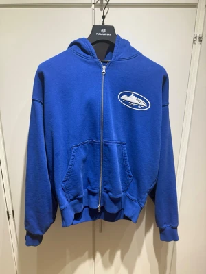 Blå zip hoodie med tryck - Blå corteiz hoodie jag inte längre har användning för! Väldigt bra skick och sällan använd! Har kvitto/orderbekräftelse! Pris är även diskuterbart.