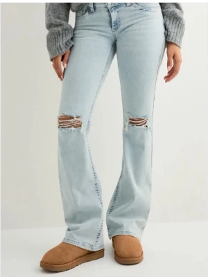 Ljusblå slitna bootcut jeans - Jag säljer dessa ljusblåa jeansen från Nelly❣️