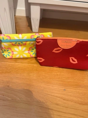 Två Clinique necessärer - Två stycken necessärer från Clinique Mått röd: 19x11cm  Mått gul: 19x10xm
